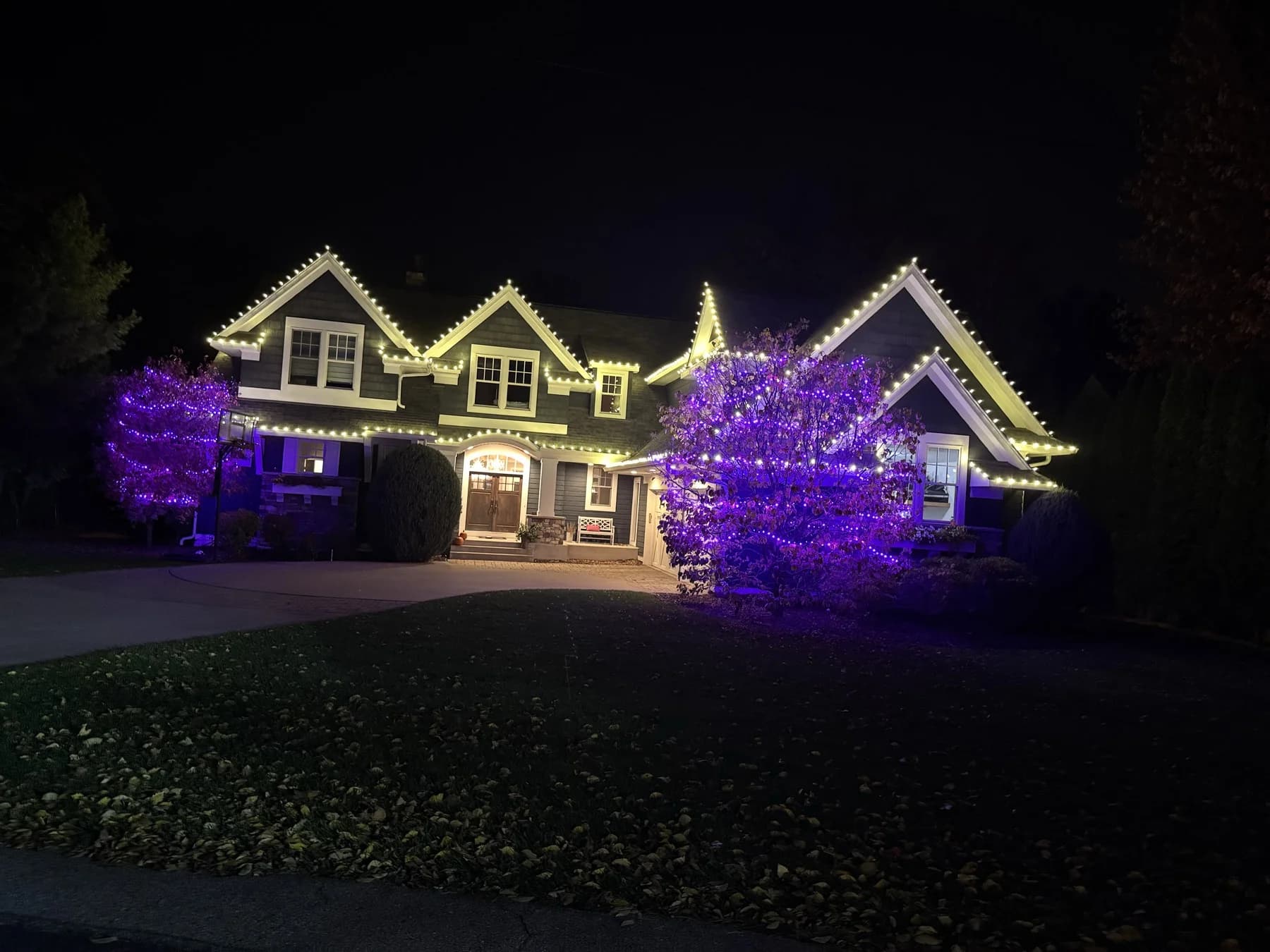 Holiday lighting installation Twin Cities MN — purple and warm white roofline lights by FCR Cleaning