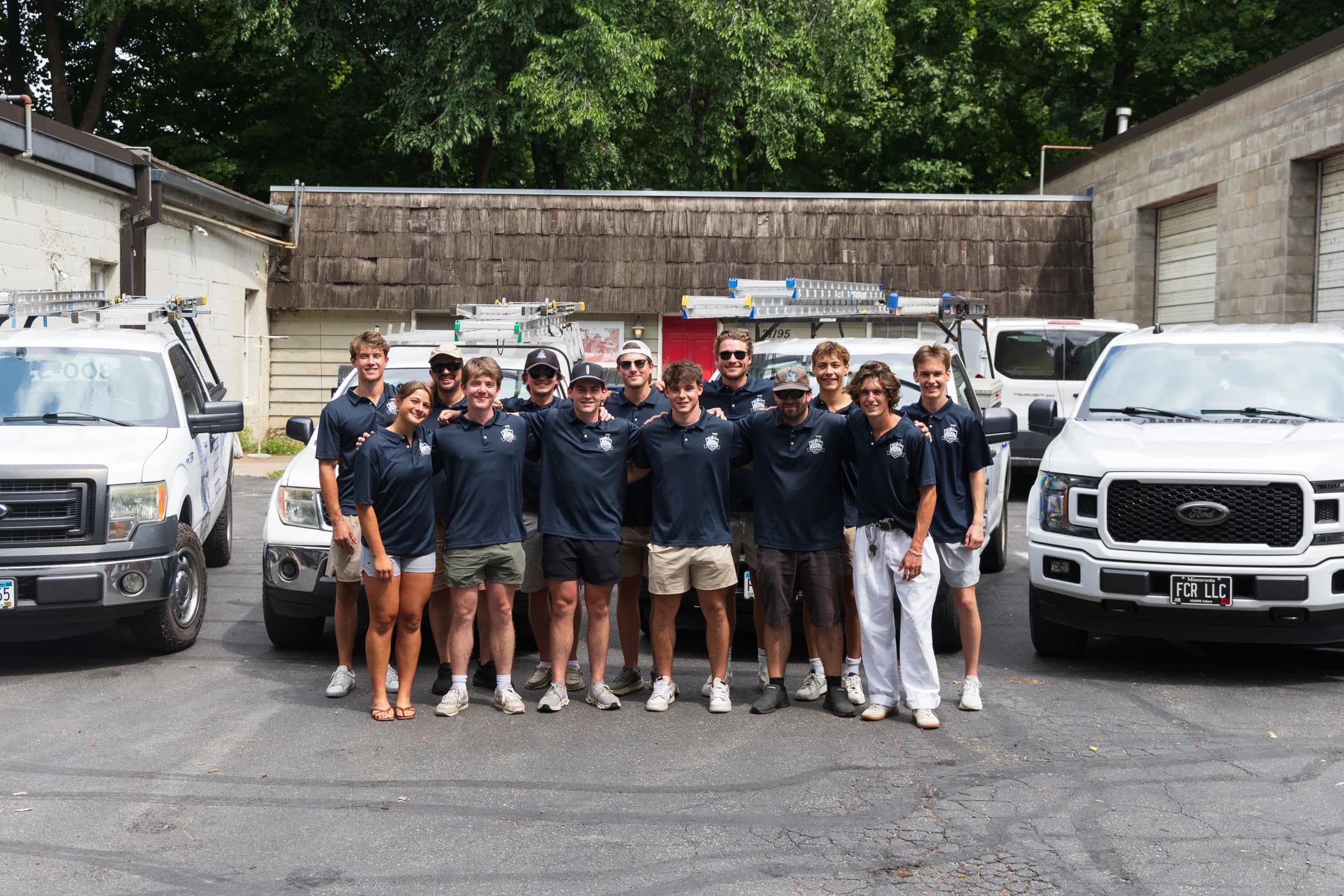 The FCR Cleaning crew relaxed and smiling in front of the truck fleet — Excelsior MN